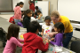 Civil engineering sophomore Paige Taylor helps a few Story County elementary school students build a K'Nex bridge on Feb. 8, 2015.