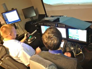 Adam Kaas and Stephen March in the flight simulator