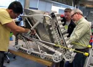 Members of Cyclone Space Mining assemble the team's robot during a recent workday in a campus lab. Left to right are Robert Prucha, a sophomore from Missouri Valley; Brandon Keesling, a sophomore from Oskaloosa; and Jim Heise, the team's faculty advisor. Photo by Mike Krapfl.