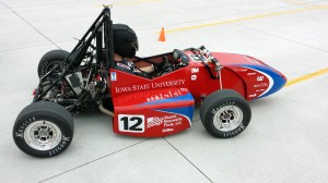 Greg Bott takes the 2014 Formula SAE racer out for another test run across a campus parking lot. This year's racer sports the colors of its primary sponsor, Patriot Renewable Fuels of Annawan, Illinois. Photo by Mike Krapfl.