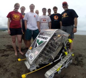 Members of Cyclone Space Mining, left to right, Katie Goebel, John Heinig, Brian Jend, Nathan Beougher, David Peiffer, Phil Molnar, Alex Grant, and Faculty Advisor Jim Heise demonstrate their robotic miner on Hilo Bay Beach in Hawaii. Photo by Pacific International Space Center for Exploration Systems.