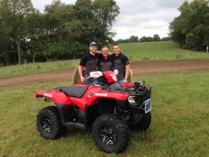 Luke (left) and Adam (right) Upah stand next to their father at an ATV race.