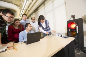 Sharma works at the computer as students look on during a traffic signal project. Photo by Craig Chandler, University of Nebraska, Lincoln. 