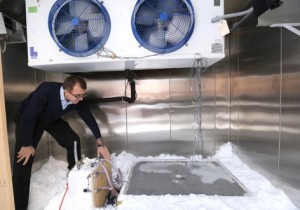 Iowa State's Halil Ceylan checks a test slab that uses heated pavement technology to melt snow and ice. One of the goals of the research project is to help smaller airports clear runways during winter storms. Photo by Christopher Gannon.