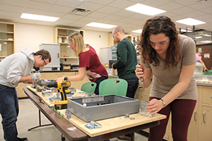 Senior Lecturer Jenny Baker  (second from left) and students building components of the electrical system boards.