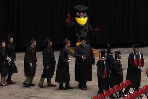 Graduates talk as they walk to their seats before the start of the undergraduate commencement ceremony Saturday at Hilton Coliseum. 