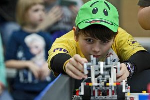 A student lines up a robot during FIRST LEGO® League Competition. (Photo by Iowa State Engineering Kids)