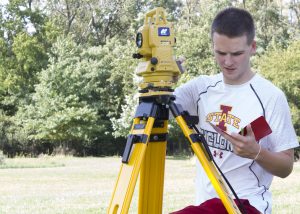 CE 111 student Austin Cabalka explores the fundamentals of observing distances, elevations, and angles (Photo by Kate Tindall)