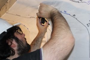 CCEE graduate student marks a concrete beam during research (By Kate Tindall)