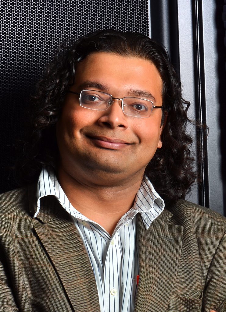 A mechanical engineering professor poses in front of a super computer