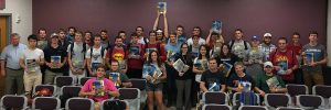 Students in CE 382 hold their books high after class with instructors Chris Williams and Ashley Buss. <i>(Photo by Kate Tindall).</i>