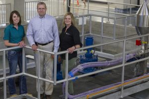 <i>(From left to right)</i> Engineering alumni Jenny Ruddy, Lance Aldrich and Kris Evans stand in the operations gallery of the new City of Ames Water Treatment Plant. <i>Photos by Kate Tindall.</i>