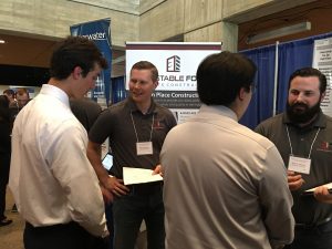 Eric Lindquist <i>(center left)</i> speaks to an engineering student during the career fair.