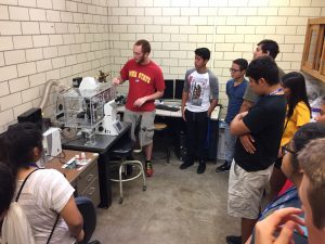 Kyle Miller, MSE graduate student, shows students lab equipment. 