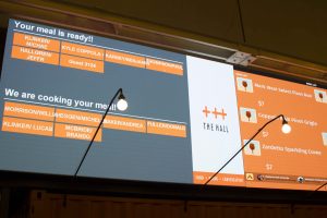 Large screens displaying wait times and ready orders are one way The Hall has sped up the food serving process. 