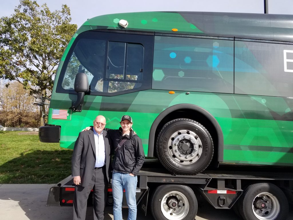 Mechanical engineering senior Ryan Saunders poses with Proterra founder Dale Hill in front of a Proterra electric bus