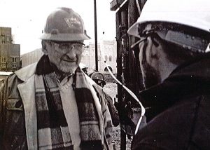 Nat Fox discusses work with a fellow engineer on a construction site. <i>Photo courtesy Dick Handy.</i>