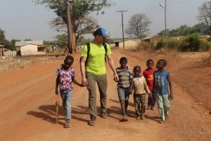 Kevin Prince (middle, in yellow shirt) walks with children in Ullo. EWB members spend time getting to know the community members while working on water distribution centers. <i> Photos courtesy Kevin Prince.</i>