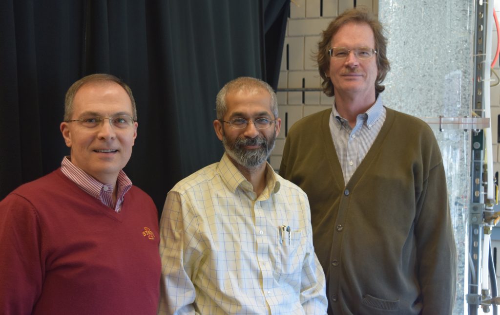 ComFRE researchers pose in front of an air-water bubble column in the Experimental Multiphase Flow Laboratory.