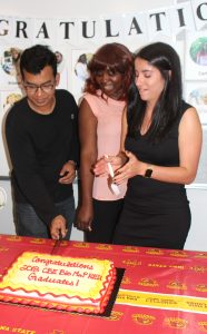 Russell Mahmood with students cutting cake
