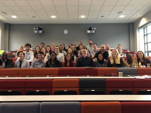 The group of post-graduate students and scholars gather in a classroom