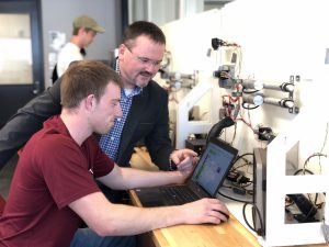 Professor works with student in hands-on lab