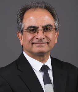 Reza Zoughi poses on a gray background, wearing a suit and tie