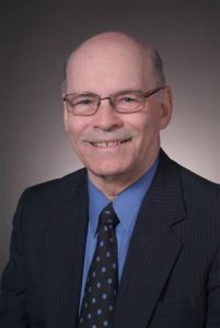 Headshot of Max Porter on a gray background.