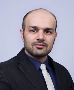 Headshot of Mohammad Tayeb Al Qaseer on a gray background.