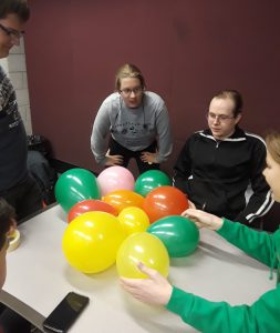 Students collaborating on balloon activity with peer mentor Dominique Serrano