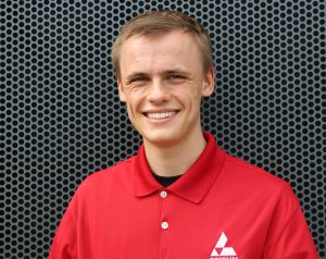 Michael Holm poses in front of a metal backdrop