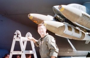 Industrial engineering faculty member poses in front of a military jet