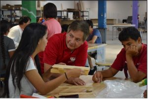 Cornelius speaking with a high school student at a table about a project