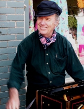 Color photo of David Wilder, smiling and wearing a hat and scarf around his neck
