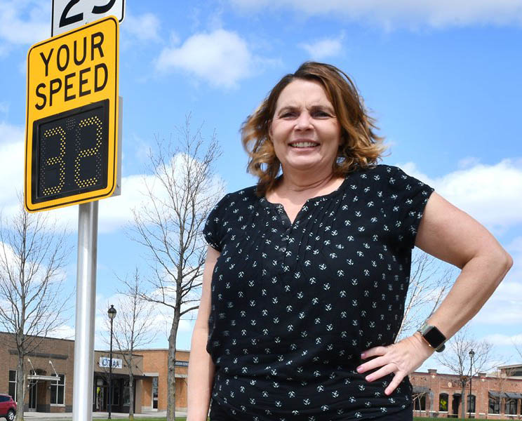 Shauna Hallmarks stands in front of a street sign