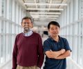 Vik Dalal and Liang Dong stand together in a skywalk on campus.
