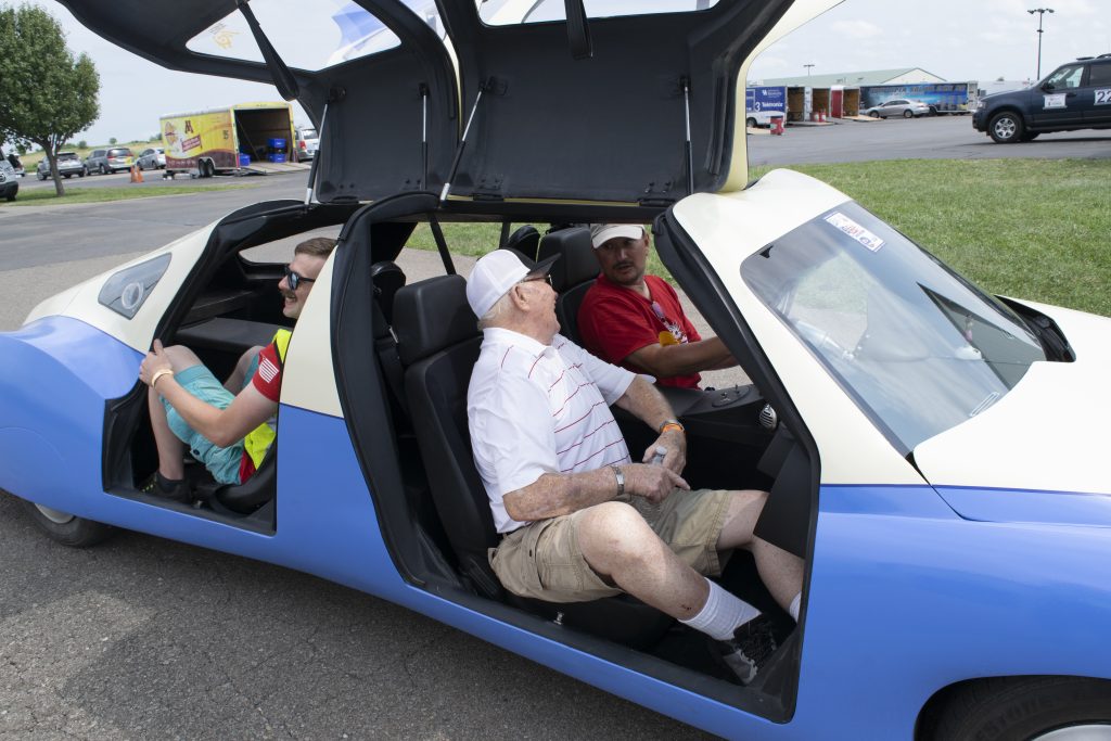 A futuristic-looking vehicle. Civil engineering alum Richard Gumtau is sitting in the passenger seat and talking to the driver.