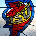 A stained glass of the old ISU logo, of the Cyclone mason and the text "ISU"