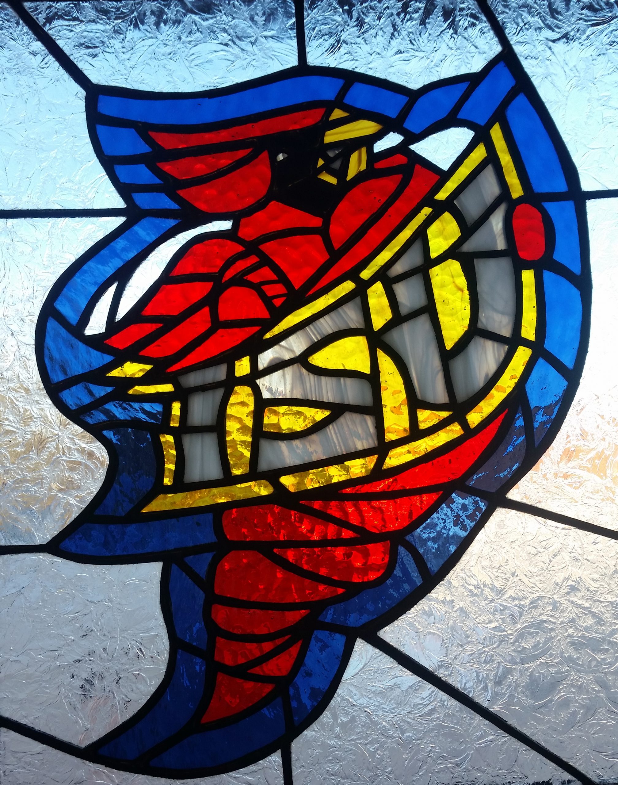 A stained glass of the old ISU logo, of the Cyclone mason and the text "ISU"