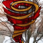 A stained glass of a red and yellow cyclone.
