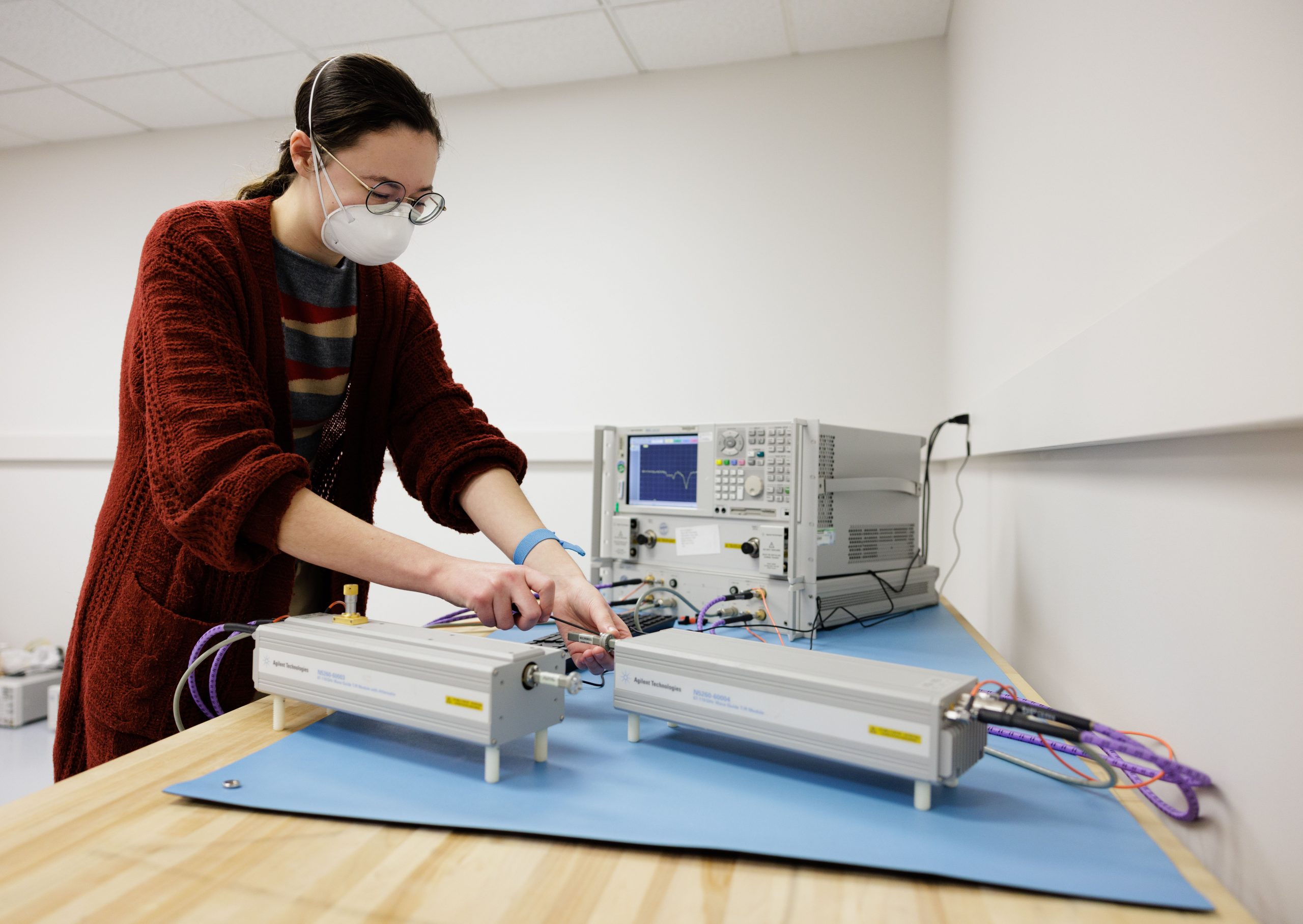 A researcher stands over an instrument while she calibrates it