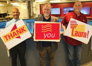 Associate teaching professor Tomas Gonzalez-Torres, Vance and Arlene Coffman Endowed Department Chair Alric Rothmayer and Professor of Practice Clayton Anderson hold "Thank you Laura!" sings for her donation