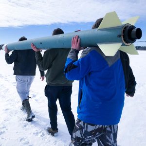 CyLaunch team members carrying rocket at test site