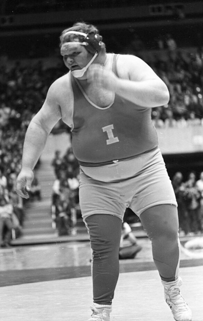 A black and white photo of Cyclone heavyweight wrestler Chris Taylor wearing a singlet. 