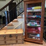 A wooden chest and a wooden cabinet built by Larry. Inside the cabinet is a bunch of quilts made by Pam