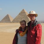Larry and Pam pose with pyramids in the background.