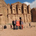 Larry poses with some friends in front of a structure in Jordan.