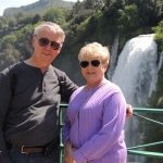 Larry and Pam pose in front of a waterfall