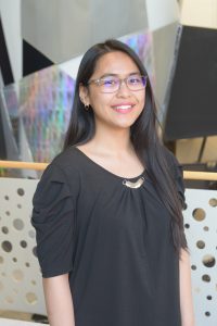 A student poses and smiles for the camera