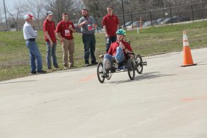 Photo of student riding Fluid Power Vehicle that looks like a bike